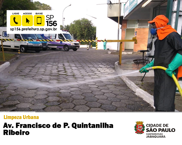 Fotografia onde mostra funcionário da Prefeitura devidamente seguro com trajes, fazendo a higienização da rua com um janto d'água